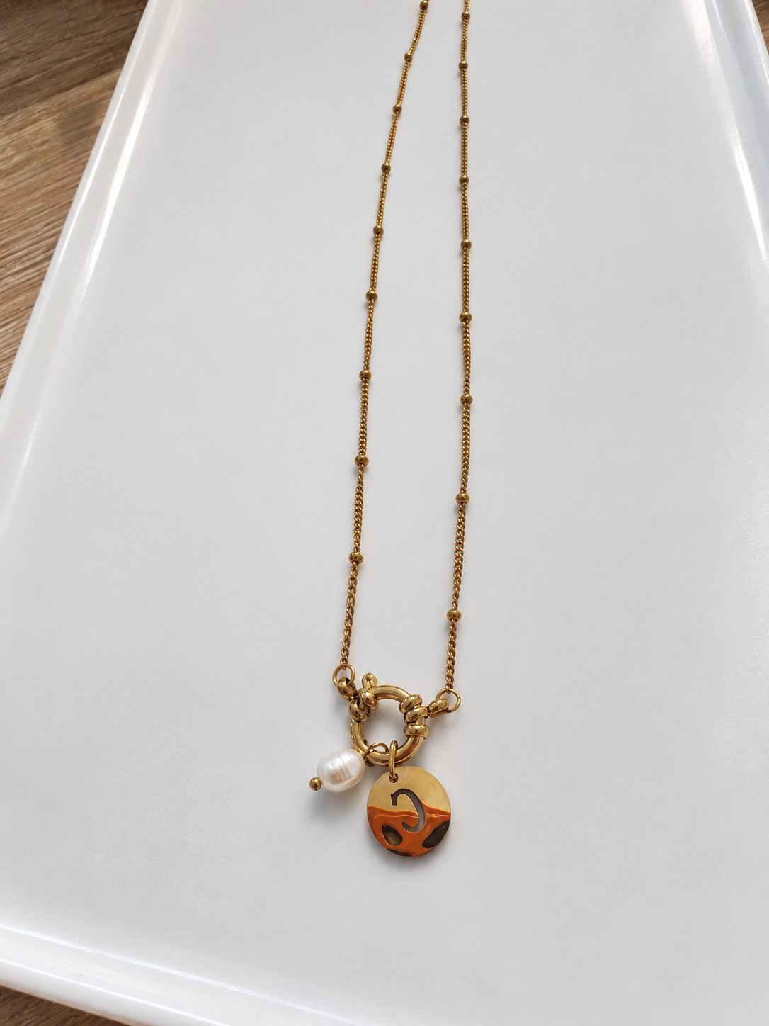 ✨ Collier doré avec perle et pendentif graphique
